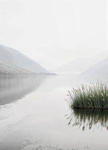 Still ruhender See mit Schilf im Vordergrund und sanften Bergen im Nebel – Naturkunst von Armin Mumper.